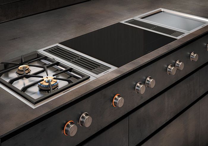 Moderne Küchenzeile mit Gas- und Induktionskochfeld sowie Bedienknöpfen Moderne Küchenzeile mit Gas- und Induktionskochfeld sowie Bedienknöpfen